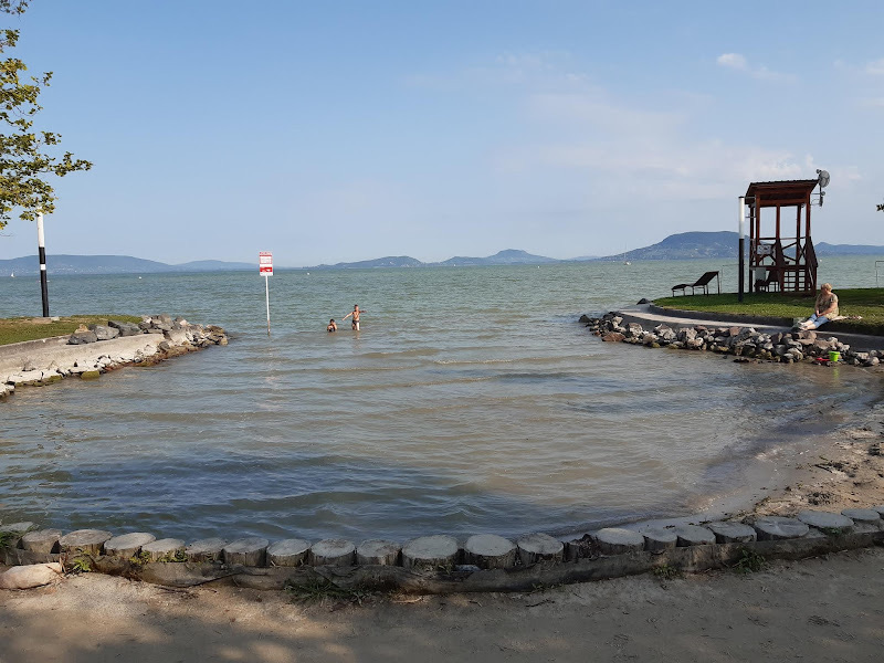 A balatonfenyvesi part sekély vízzel, a háttérben a badacsonyi hegyekkel
