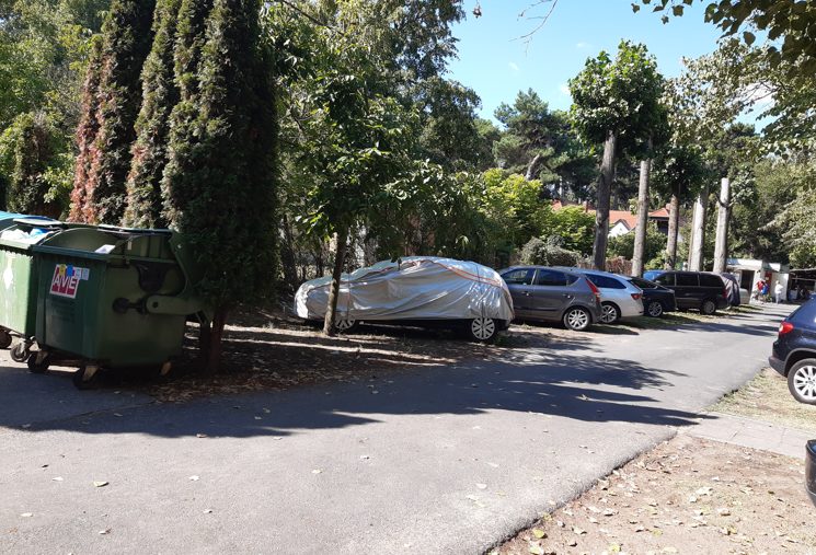 A zöld hulladékkonténerek a kerítés mellett