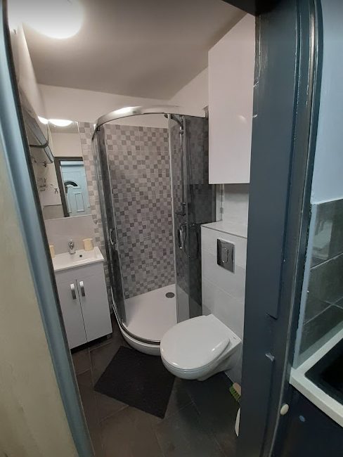A fürdőszoba a WC feletti szekrénnyel, mellette a vízelzáró csappal
